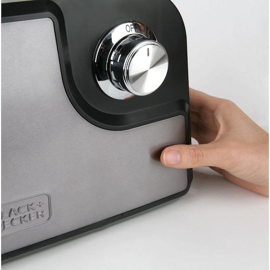 BLACKDECKER BXMMA1000E photography of stainless steel appliance with control knob and hand turning it