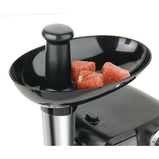 Photo of BLACKDECKER BXMMA1000E meat mincer tray with raw meat cubes, close-up angle.