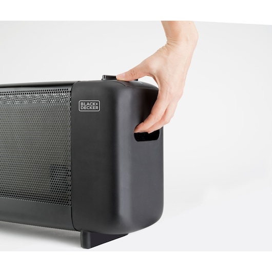 Photo of BLACK+DECKER BXMRA1500E heater, close-up view of black side handle with hand holding it.