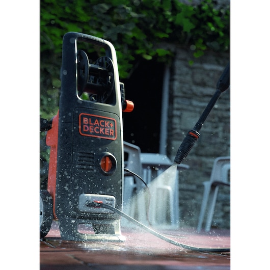 BLACKDECKER BXPW1700E pressure washer spraying water on patio, photographed outdoors, product in use