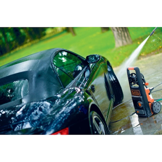 BLACK+DECKER BXPW2000PE pressure washer cleaning black convertible car outdoors on driveway.