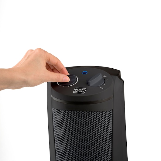 Photo of BLACK+DECKER BXSH2002E black heater with hand adjusting control knob, front angle.