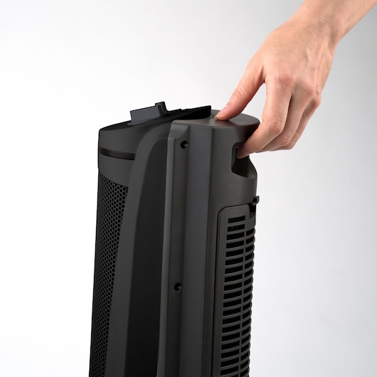 BLACKDECKER BXSH2002E black tower heater with handle, side view, hand holding the top.
