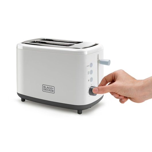 A person adjusts the settings on a white BLACK+DECKER toaster with two slots and control buttons on the side.