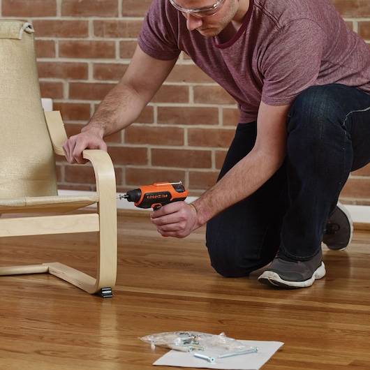 BLACKDECKER CS36BSCES cordless screwdriver used to assemble wooden chair indoors.