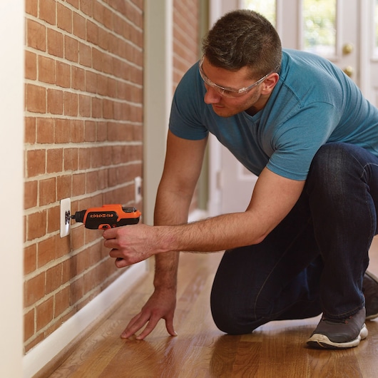 Photo of BLACKDECKER CS36BSCES cordless screwdriver in use on wall socket near brick wall indoors.