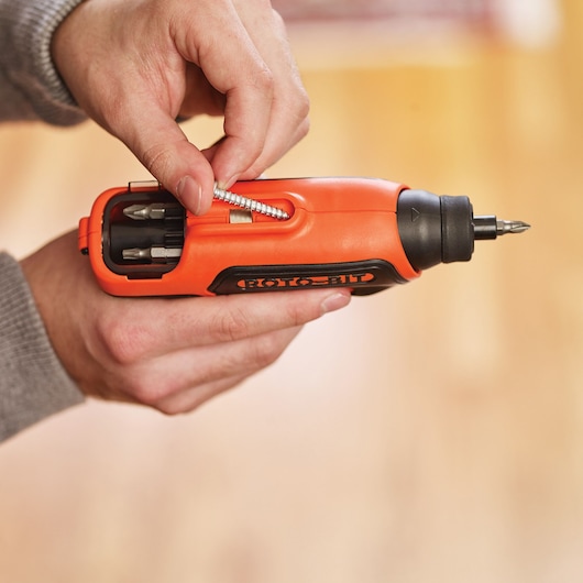 Photo of BLACKDECKER CS36BSCES orange cordless screwdriver with integrated bit storage, person adding screw.