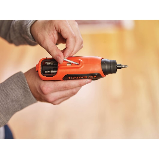 BLACKDECKER CS36BST orange cordless screwdriver with bit storage being loaded, close-up photography.