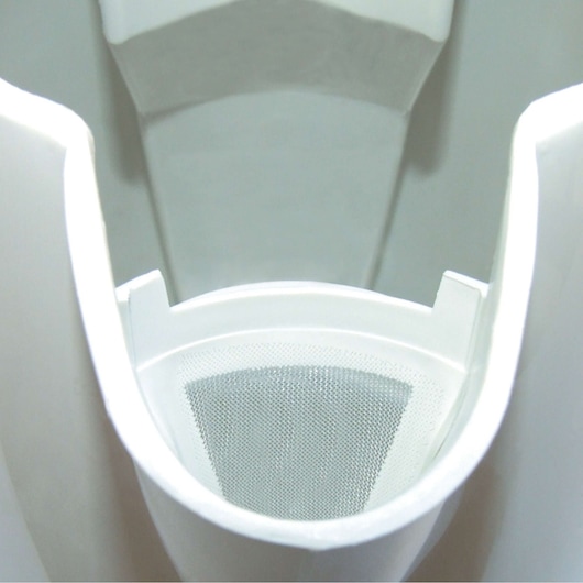 Close-up image of a white plastic filter holder with a mesh filter inside, likely part of a household appliance.