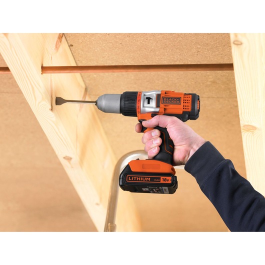 BLACKDECKER EGBHP1881K cordless drill driver used on wood beam, orange and black, 18V lithium battery.