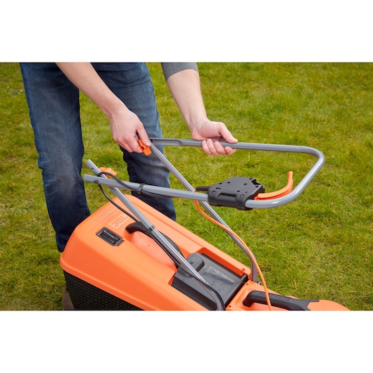 BLACKDECKER EMAX32S lawn mower handle adjustment, close-up view on grass.