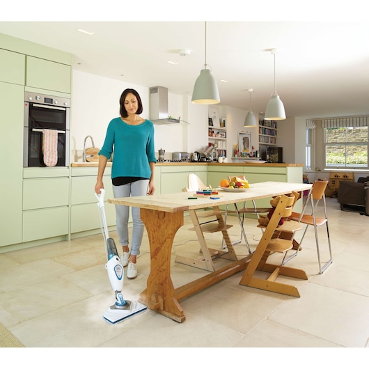 Photo of BLACKDECKER FSM1616 steam mop in use on kitchen tile floor near wooden dining table.