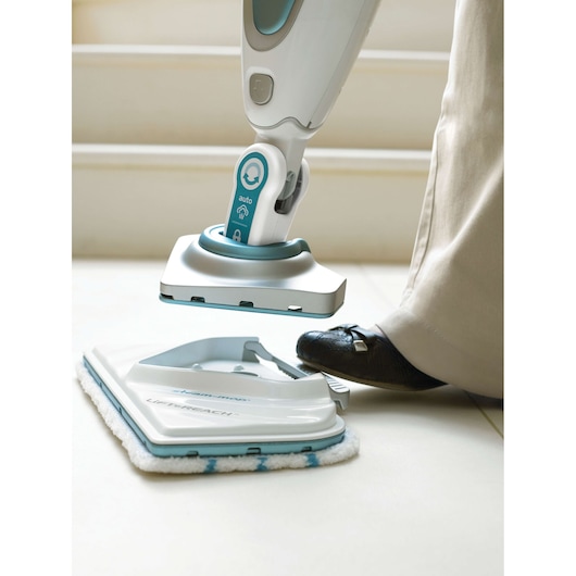 BLACKDECKER FSM1630 steam mop with foot on pad release, white and blue, close-up on floor use.
