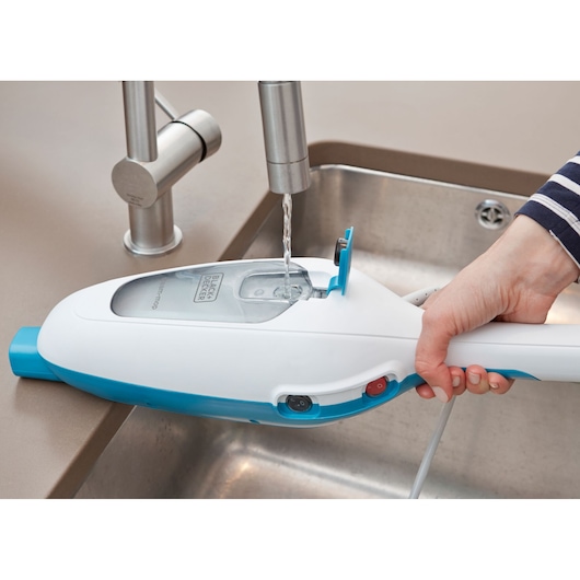 Photo of BLACKDECKER FSMH13E5 steam mop being filled with water at a sink, side view.