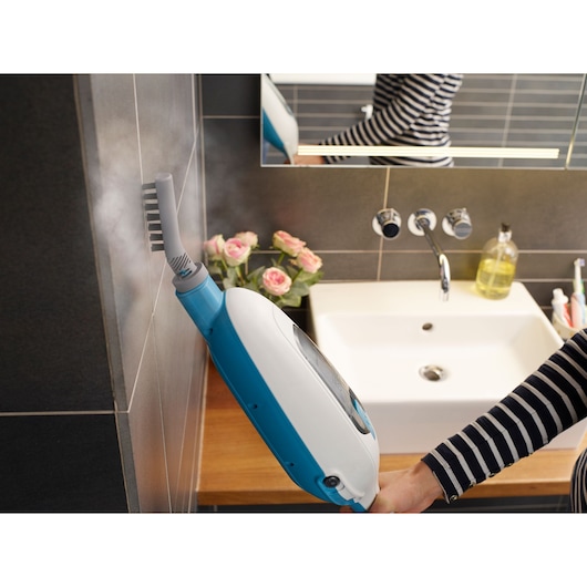 BLACKDECKER FSMH13E5 steam cleaner cleaning bathroom wall tiles near a white sink.
