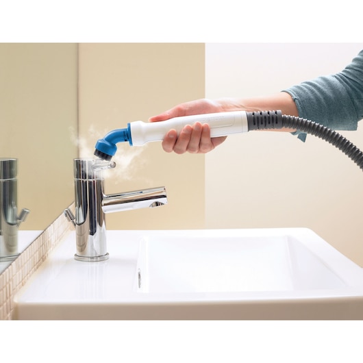 BLACKDECKER FSMHBA steam cleaning tool used on bathroom faucet, close-up side view.