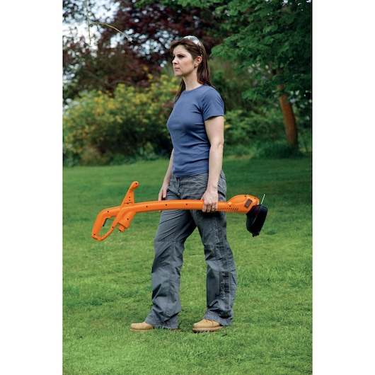BLACKDECKER GL360SB grass trimmer held by person on garden lawn.