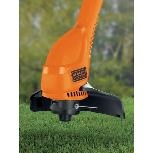 BLACKDECKER GL360SB orange grass trimmer cutting grass, close-up outdoor photography.