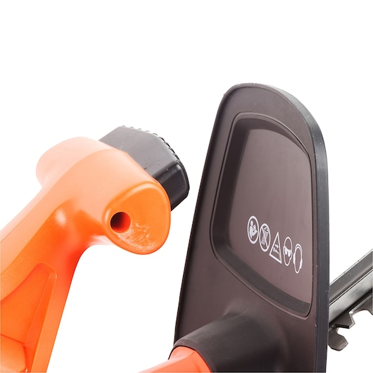 Close-up view of the handle and safety guard of an orange and black BLACK+DECKER GT4245 hedge trimmer, showing warning icons on the guard.