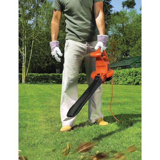 BLACKDECKER GW2810 leaf blower in use outdoors, orange and black design, person holding unit on grass.