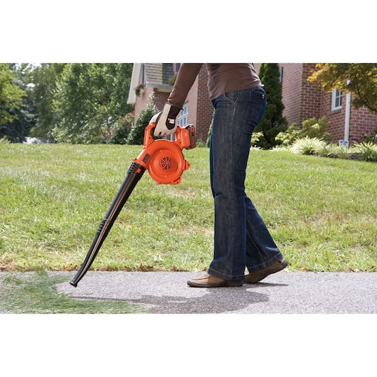 BLACKDECKER GWC1800L20 cordless leaf blower in use outdoors on grass and pavement.