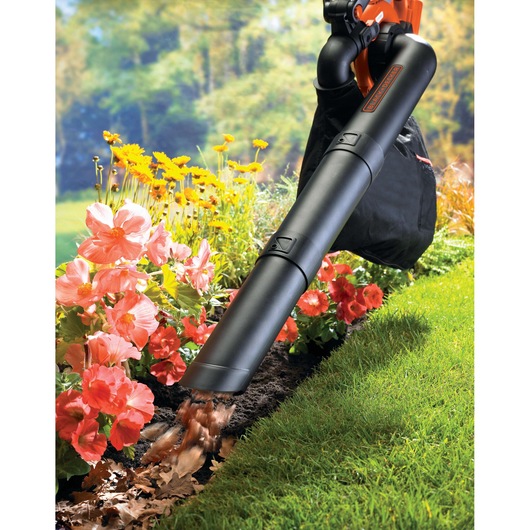 BLACK+DECKER GWC3600L20 leaf blower in use near flowers and lawn, collecting fallen leaves.