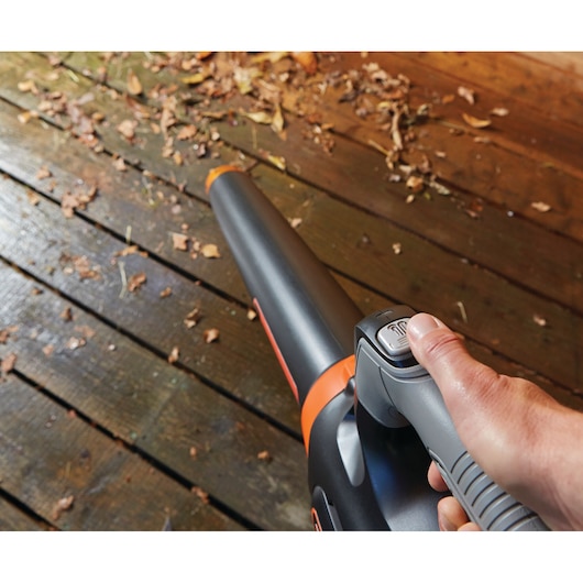 BLACKDECKER GWC54PC leaf blower close-up, handheld on wooden deck with fallen leaves.