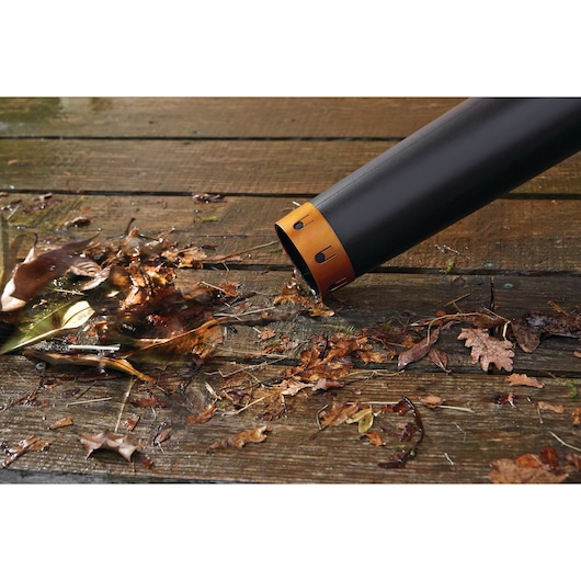 BLACKDECKER GWC54PC leaf blower tube clearing wet leaves on wooden decking, close-up photography.