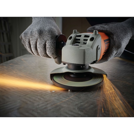 BLACKDECKER KG115 angle grinder in use on metal surface with sparks flying, close-up photography
