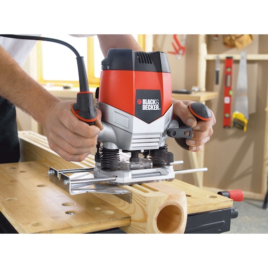 BLACKDECKER KW900E wood router in use on workbench, red and silver design, woodworking tool.