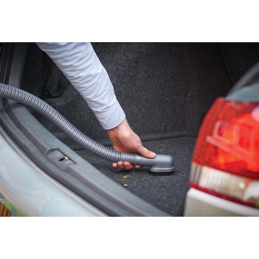BLACKDECKER NV1210AV car vacuum with hose cleaning trunk interior.