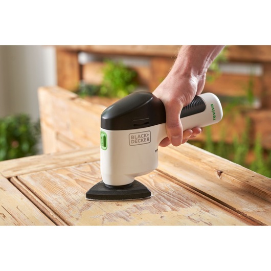 BLACKDECKER REVDS12C detail sander in use on wooden surface, close-up angle.