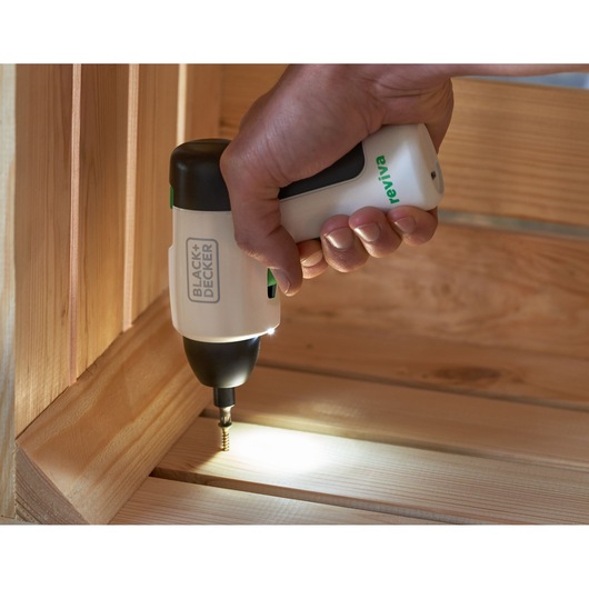 Photo of BLACK+DECKER REVSD4C cordless screwdriver with LED light, in use driving a screw into wooden boards.