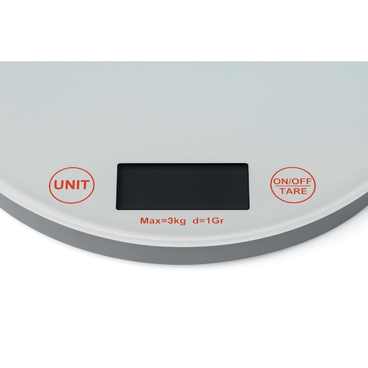 A close-up image of a digital kitchen scale. The scale has a circular shape with two visible buttons labeled 'UNIT' and 'ON/OFF TARE' in red. There is a black digital display in the center. Below the display, the text ‘Max=3kg d=1Gr’ is printed, indicating the maximum weight capacity and precision.