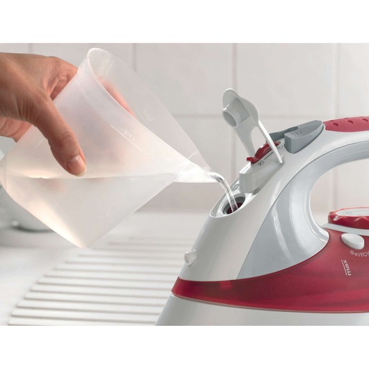 Photo of BLACKDECKER XT2040 steam iron with water being poured into the reservoir, close-up angle.