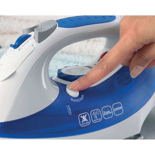 BLACKDECKER XT2200 steam iron close-up with hand pressing self-clean button, blue and white design.